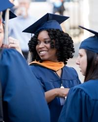 A Black and white woman in graduation regalia