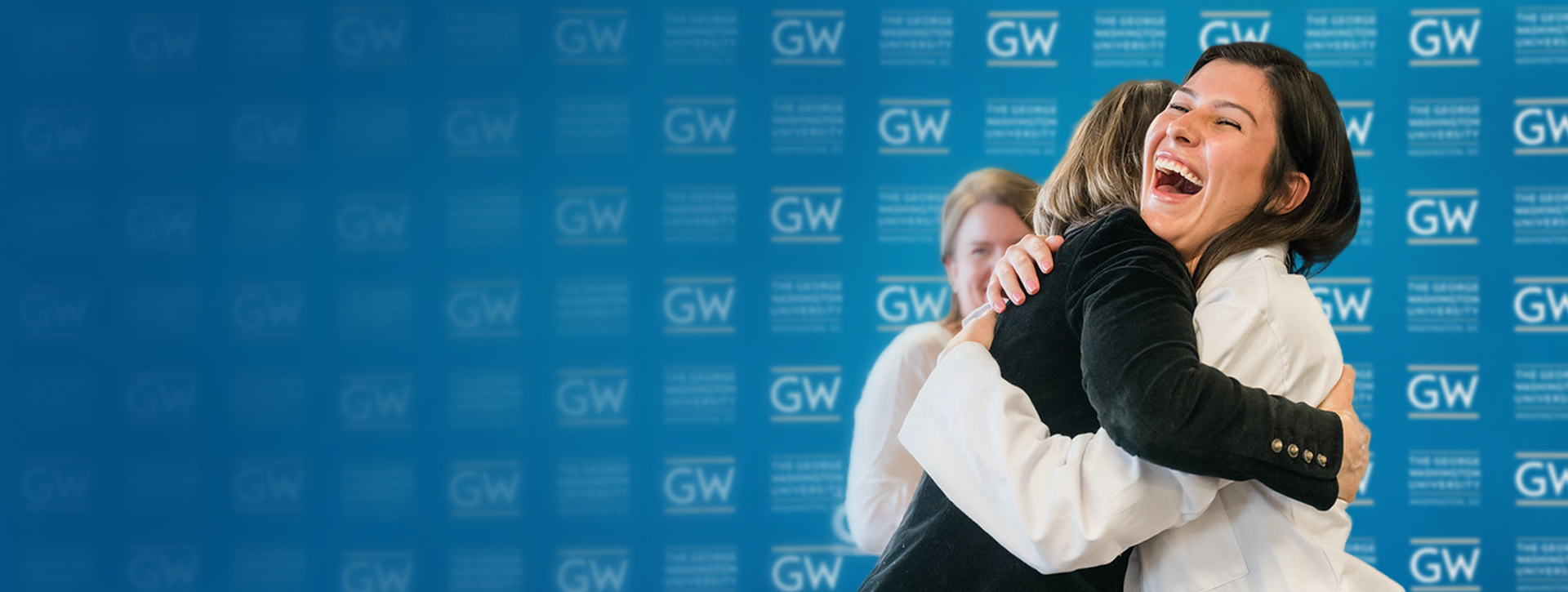 Nursing student hugging mentor while receiving White Coat