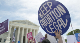 sign reading "Keep Abortion Legal" being held in front of the Supreme Court